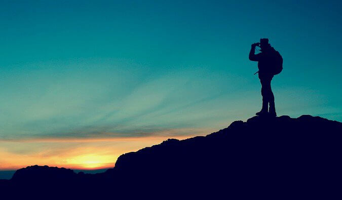 A man on a mountain as the sun goes down