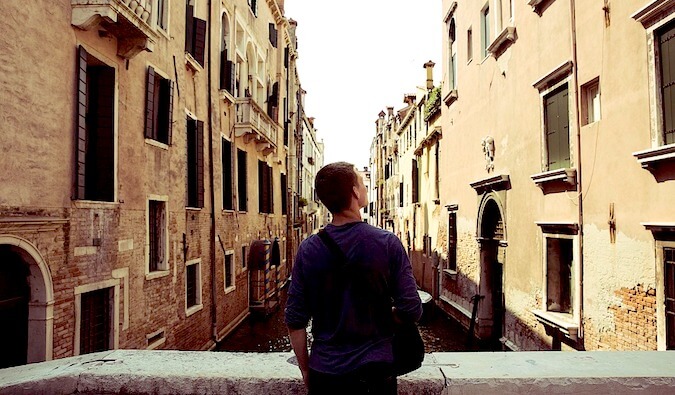 a guy looking over the canals of Venice, Italy