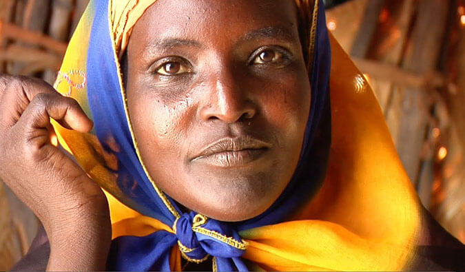 Portrait photo of a woman wearing a bright yellow and blue headscarf