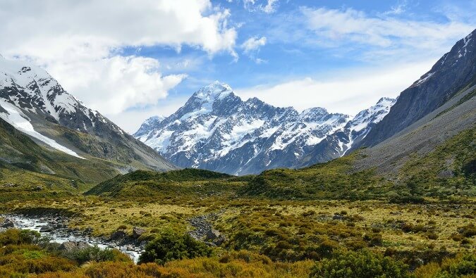 classic shot of the New Zealand countryside with snow caped mountains and grass
