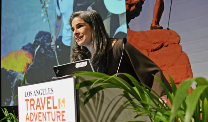 Image of Pauline Frommer talking into a microphone at Travel Adventure conference