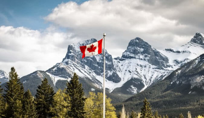A Canadian flag waving in the mountains