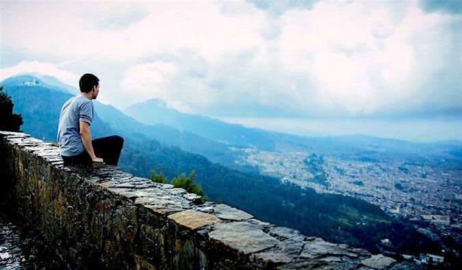 A guy looking out over some mountains at a valley