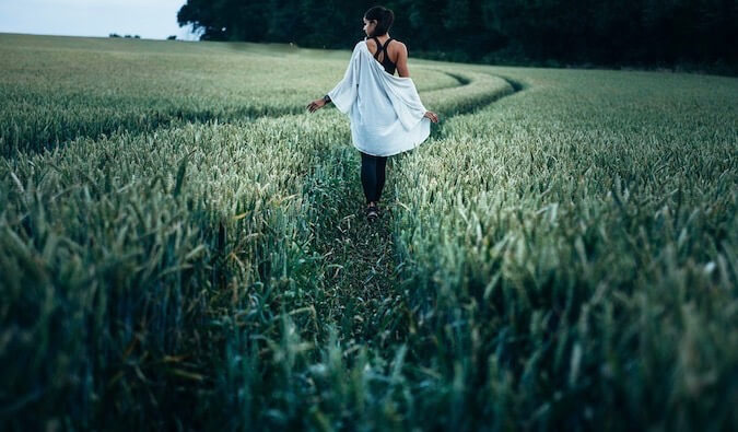 A woman alone walking in tall grass