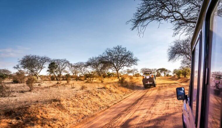 A jeep driving down the savannah plains of Kenya while on safari