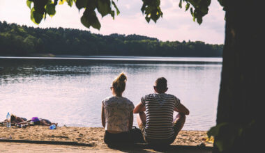 A couple sitting by the lake together