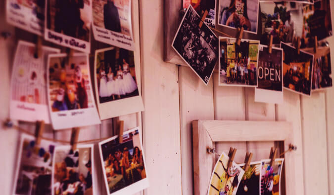 printed polaroid photos pined onto boards on a wooden wall