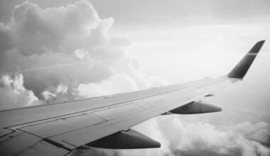 A plane flying in the air in black and white