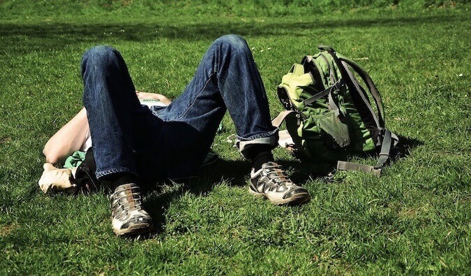 A guy sleeping in a park afetr a long day of sightseeing