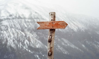 A small wooden sign pointing the way in the mountains