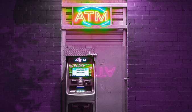 a purple ATM covered in graffiti