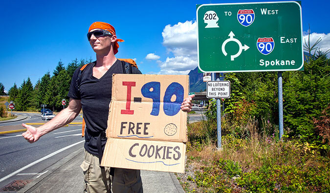 Expert Vagabond hitchhiking through the USA with a sign that says free cookies