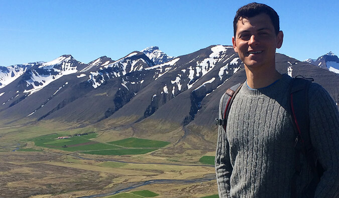 Nomadic Matt stood in front of snow caped mountains