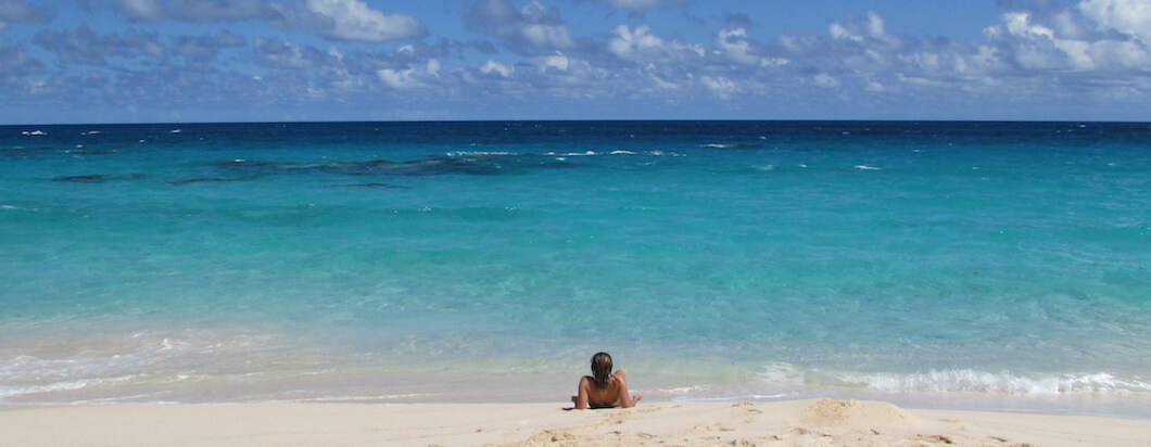A solo traveler lounging on the beach in bermuda