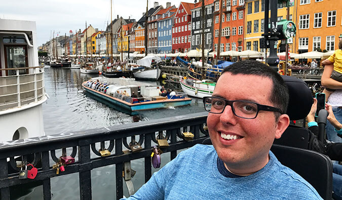 man in a wheelchair smiling on a bridge in Amsterdam