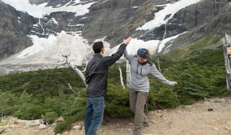 Nomadic Matt high fiving a fellow hiker on a glacier