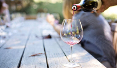 A glass of wine being poured on a table outside in Napa Valley, USA
