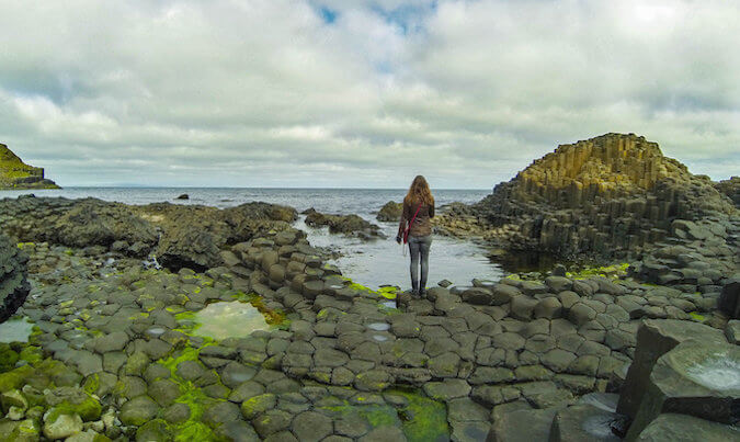 Solo girl traveler looking at beautiful rocky Icelandic landscape