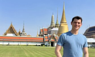 Nomadic Matt standing in front of a temple in Thailand