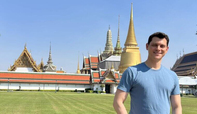 Nomadic Matt standing in front of a temple in Thailand