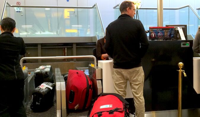 A guy checking in to a flight and checking his bags
