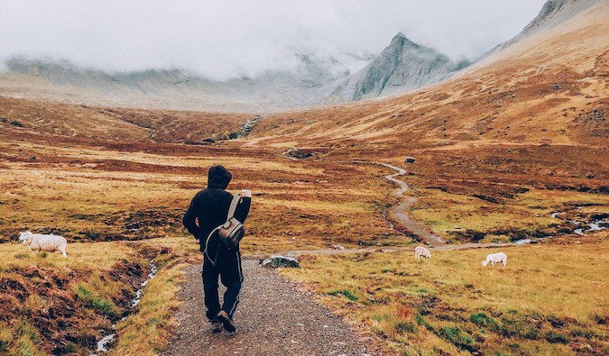 A guy wandering near mountains on a foggy day