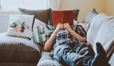 A man reading a book while sitting on his couch