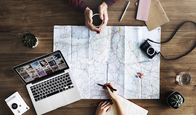 People planning a trip over a map and computer