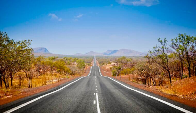 A wide open road in the Outback of Australia on a bright and sunny day