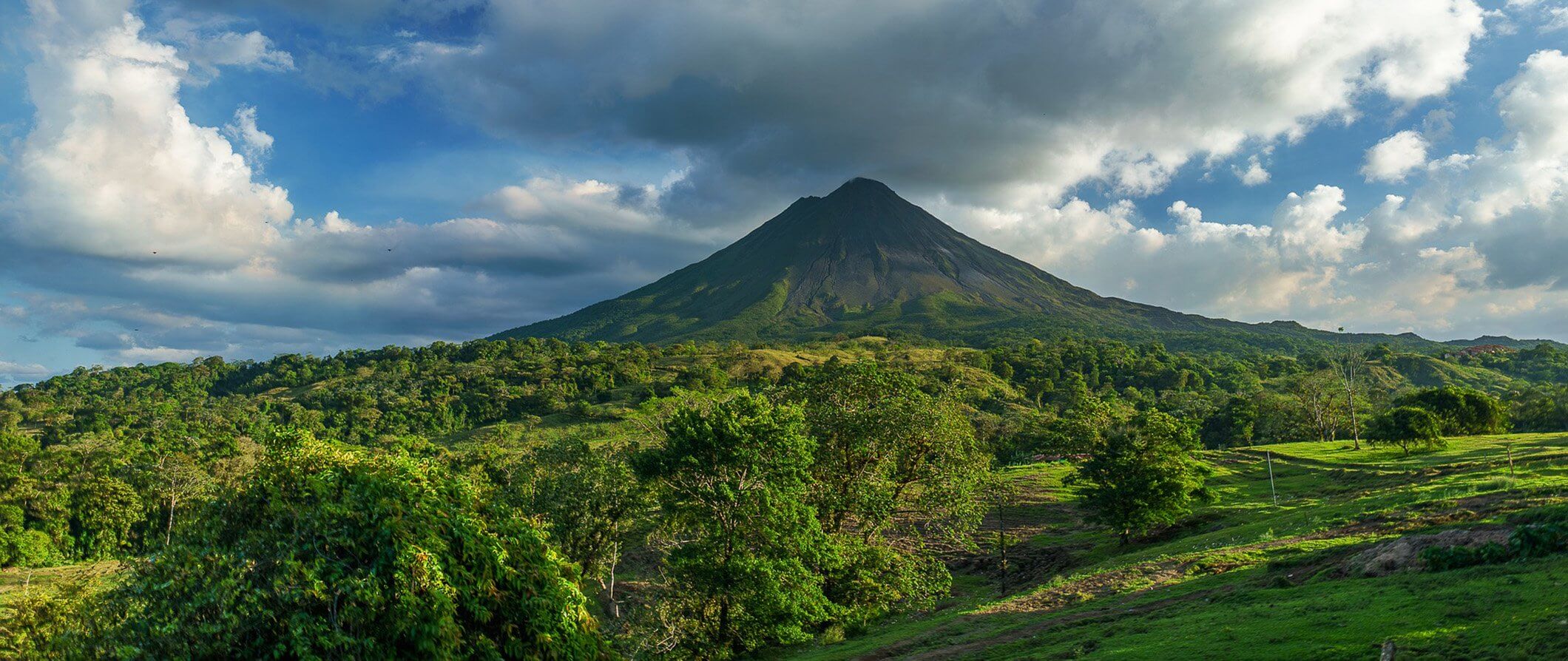 Arenal Volcano in Costa Rica. Surrounded by Jungle with clouds forming just above the Volcano
