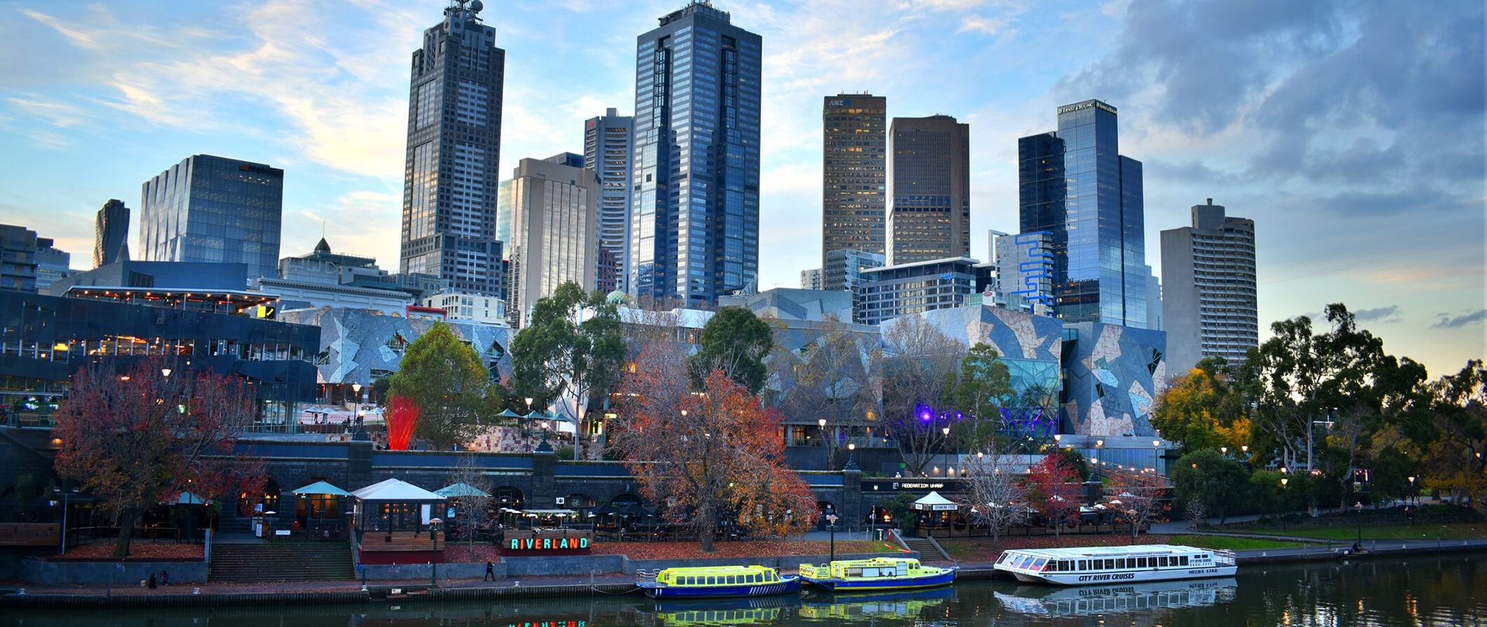 the water front in Melbourne, Australia. tall skyscrapers in the background the water with boats in the foreground