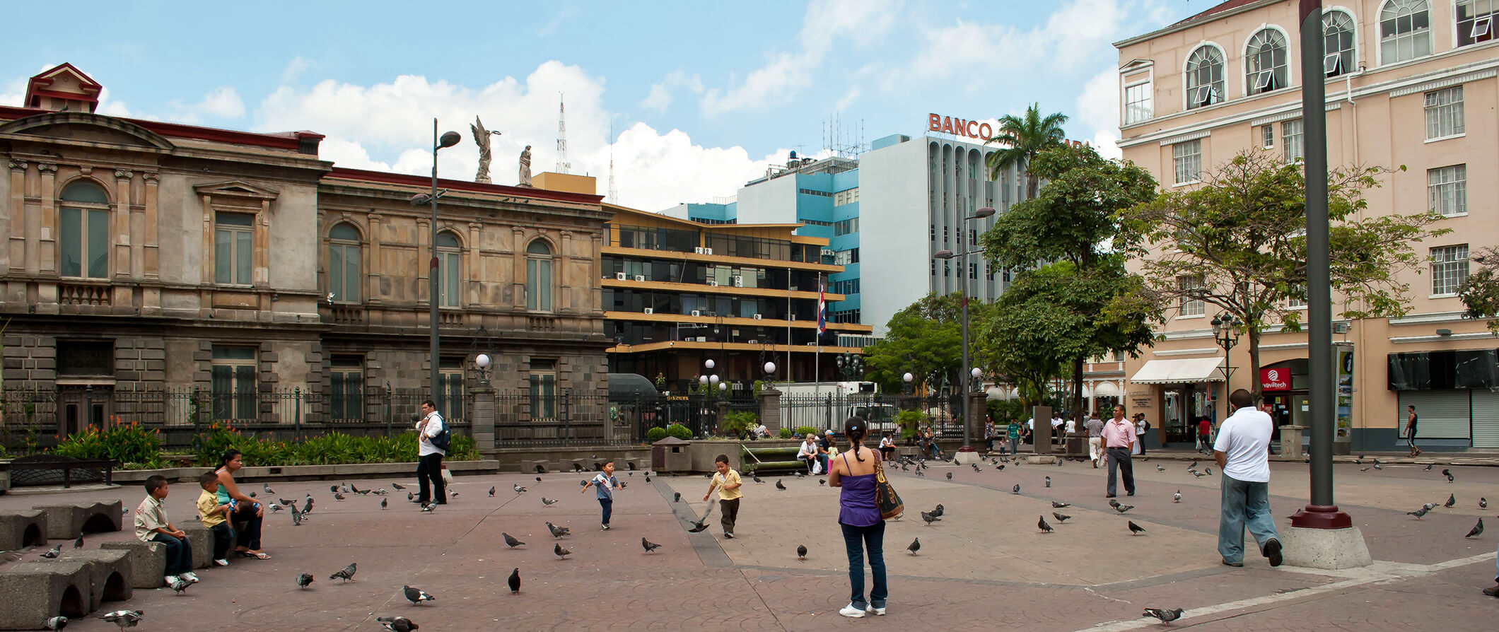 a Plaza in San Jose Costa Rica. People walking through the plaza, birds and official buildings