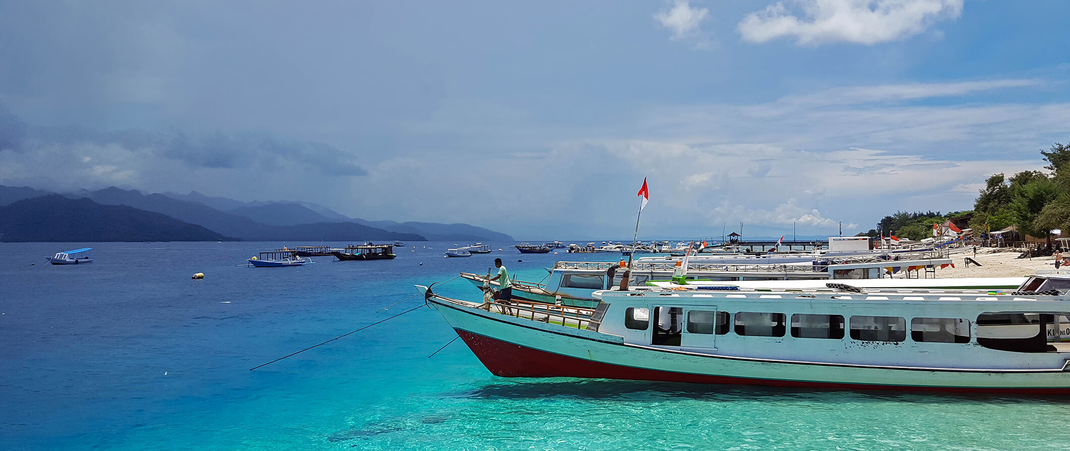 boats anchored at a beach in the Gili Islands