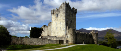Irish castle with blue sky and green hills