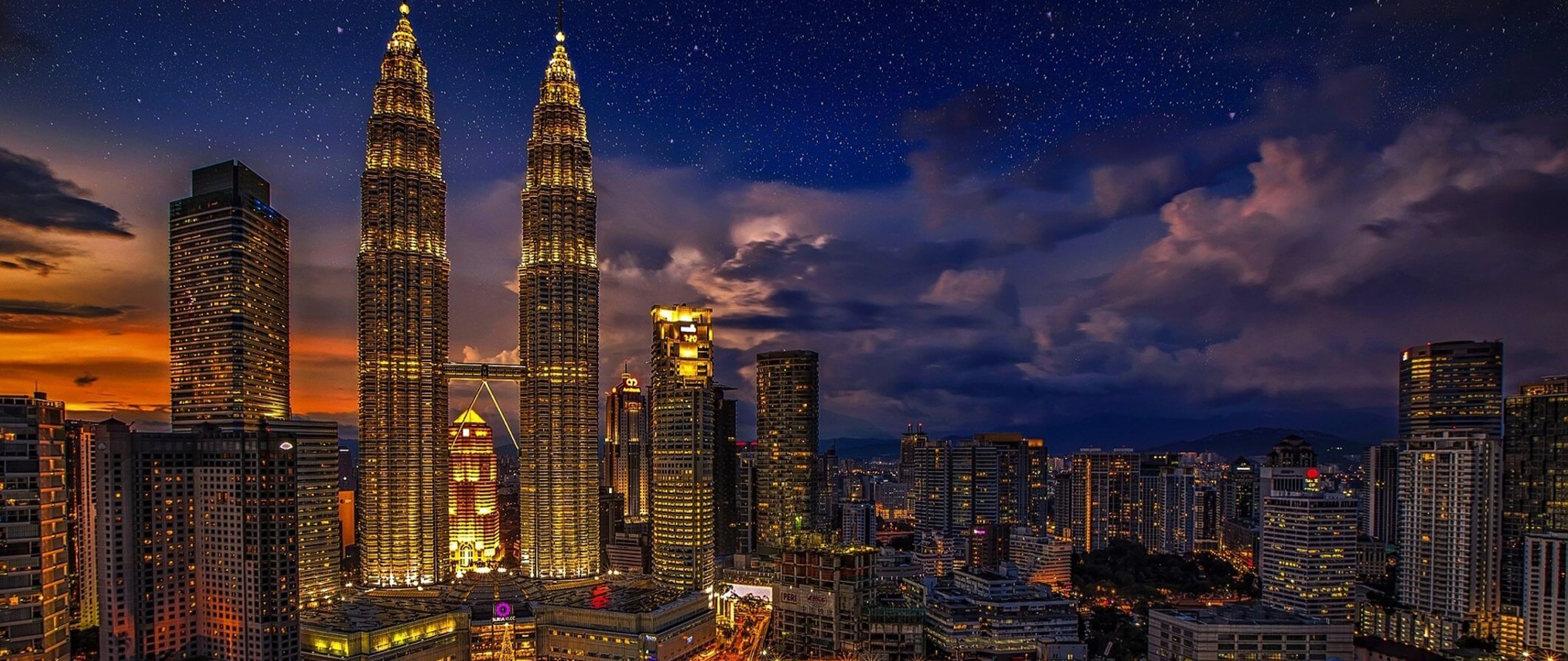 The stunning skyline of Kuala Lumpur lit up at night featuring the Petronas Towers