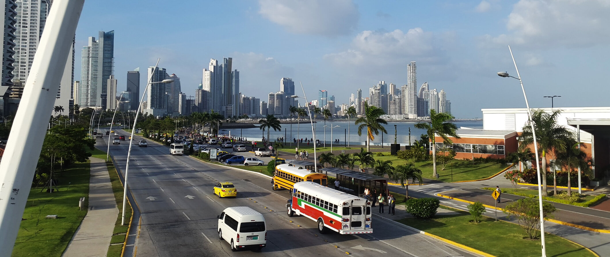 highway in Panama city. Cars and busses on the road with tall buildings to the rear.