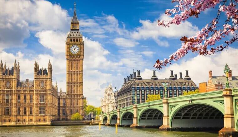 View of Big Ben and Parliament across the river Thames with cherry blossoms in bloom in London, England