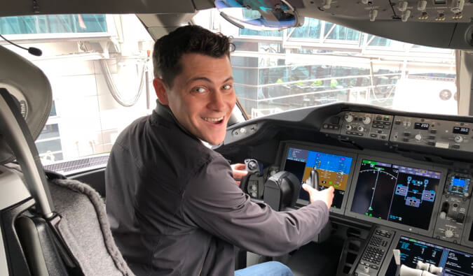 Nomadic Matt pictured in the cockpit of an airplane holding the control of the plane