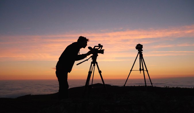 A guy taking photos during a sunset