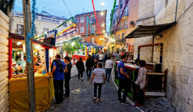 people walking down a market street in lisbon, portugal