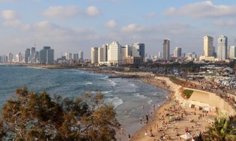 the beach in Tel Aviv with skyscrapers in the background
