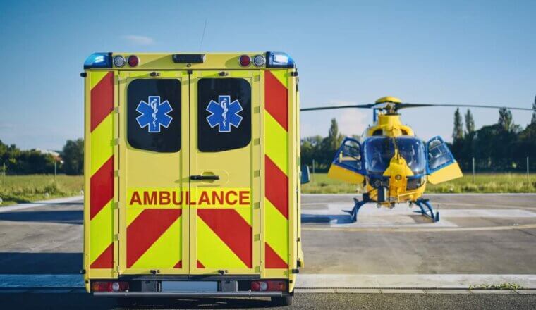 An ambulance parked next to a helicopter on a medical evacuation