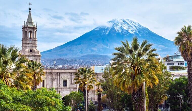 The skyline of Arequipa, Peru with a historic church in the foreground and a volcano in the background