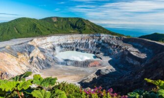 panoramic view of the Poas Volcano with its aquamarine caldera surrounded by rocky cliffs in Costa Rica
