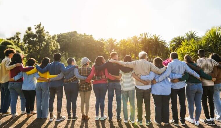 A group of of travelers standing in a circle hugging while traveling abroad