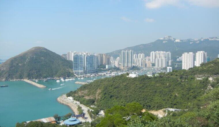 The skyscraper-filled skyline of Hong Kong, surrounded by rolling hills