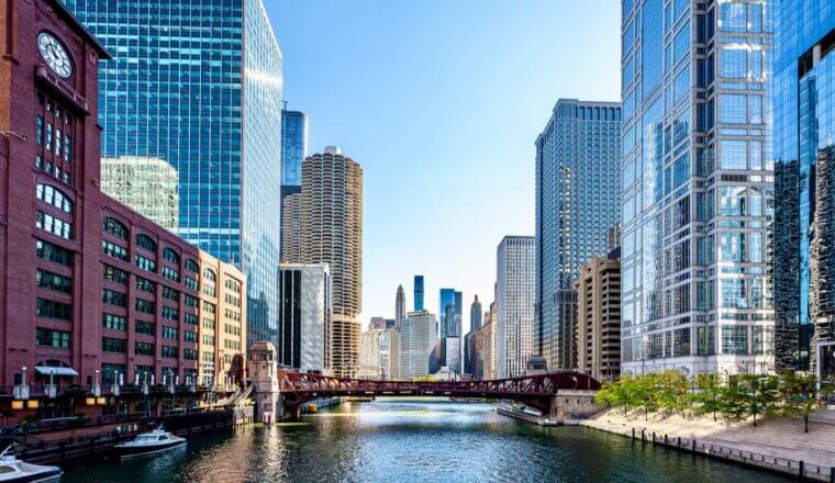 A busy downtown Chicago, USA divided by the river on a quiet, sunny day with a bridge in the distance