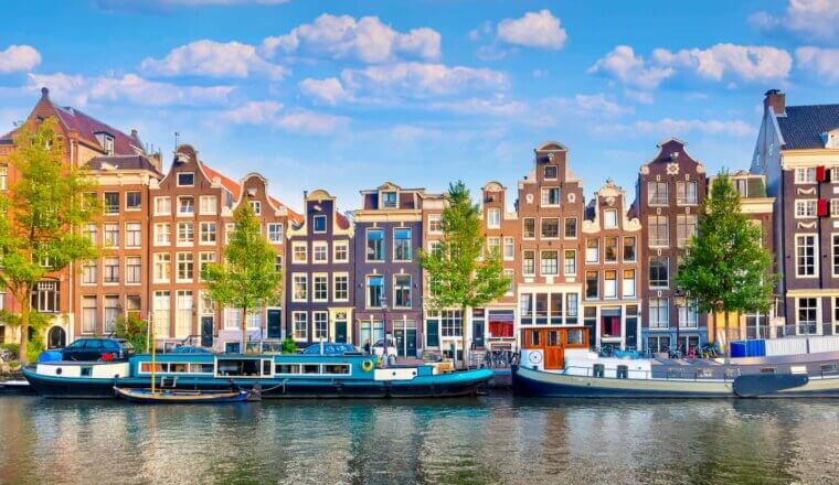 A sunny day along the rows of old houses near the canal in Amsterdam