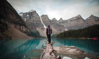 A solo traveler standing on a log in Alberta, Canada