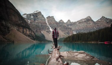 A solo traveler standing on a log in Alberta, Canada